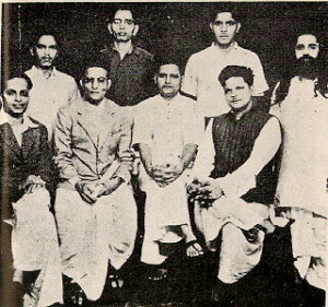 A group photo of people accused in the Mahatma Gandhi's murder case. Standing: Shankar Kistaiya, Gopal Godse, Madanlal Pahwa, Digambar Badge. Sitting: Narayan Apte, Vinayak D. Savarkar, Nathuram Godse, Vishnu Karkare